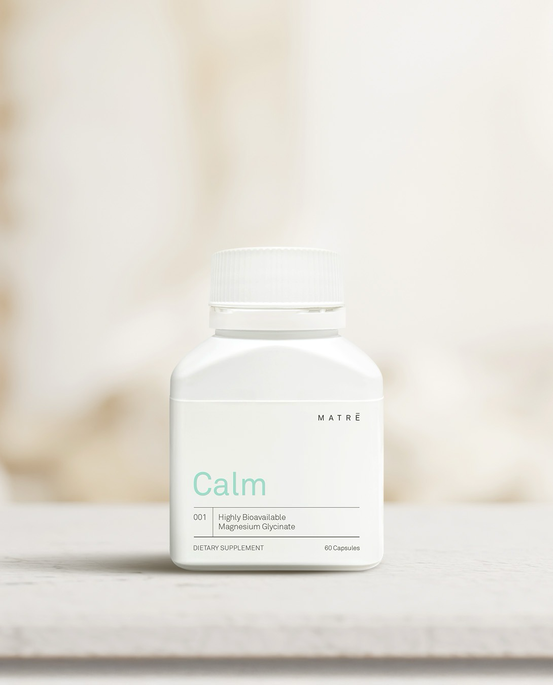 Matrē Calm magnesium glycinate, 60 capsules, on a warm stone surface