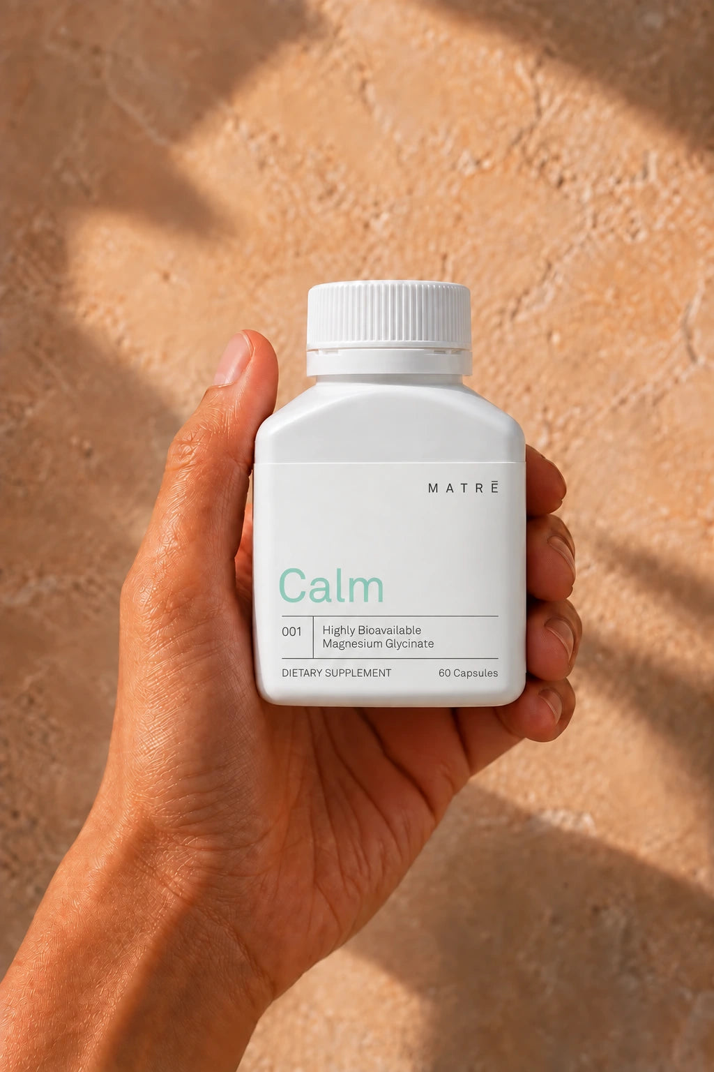 A hand holding a Matrē Calm concept bottle
